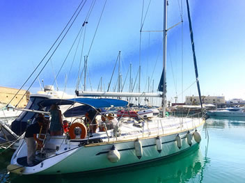 Sailing under blue skies with the Cretan coastline in sight